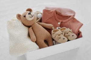 Babykleidung und Spielzeug in einer Box